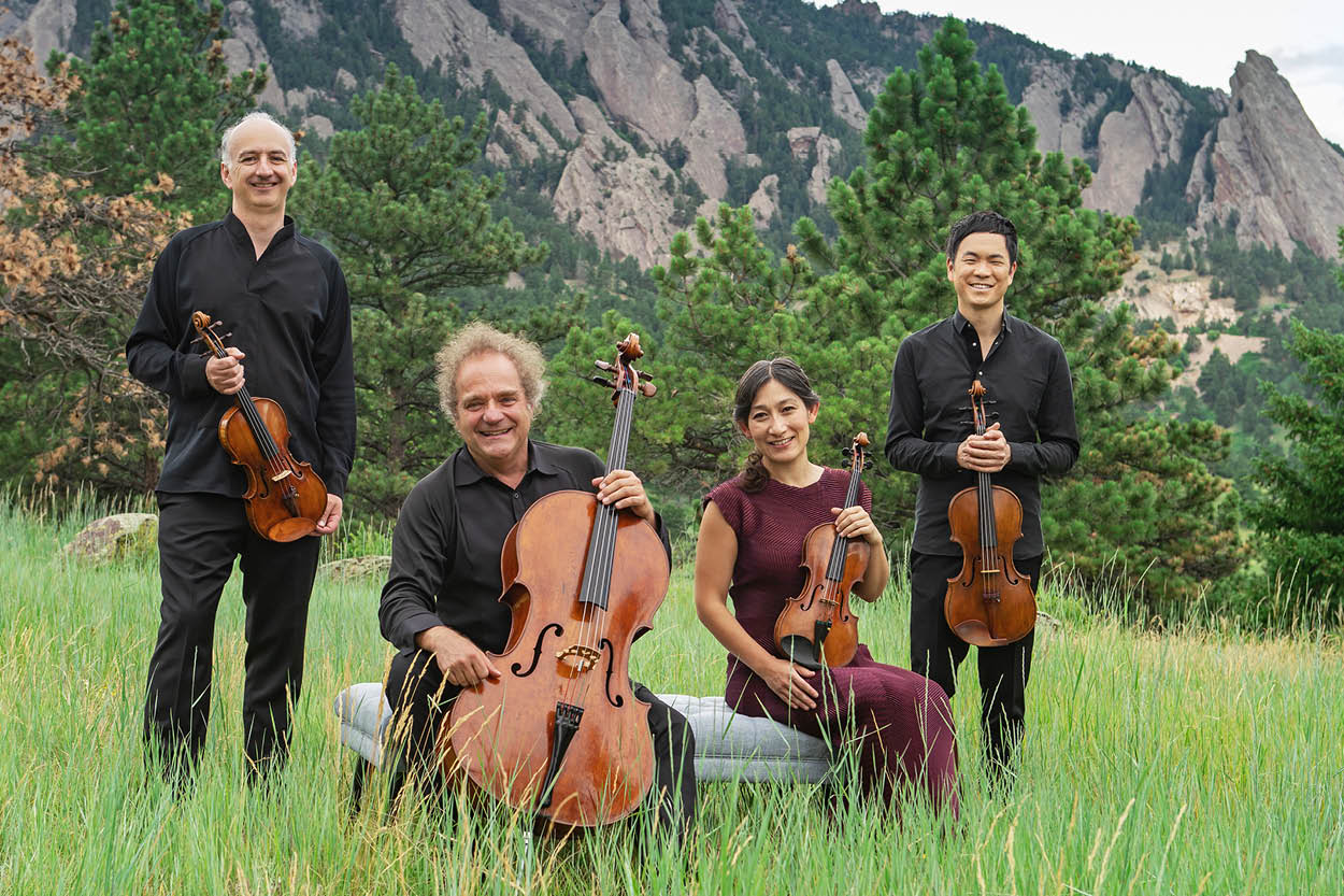 Members of Takács Quartet pose with their instruments outside.